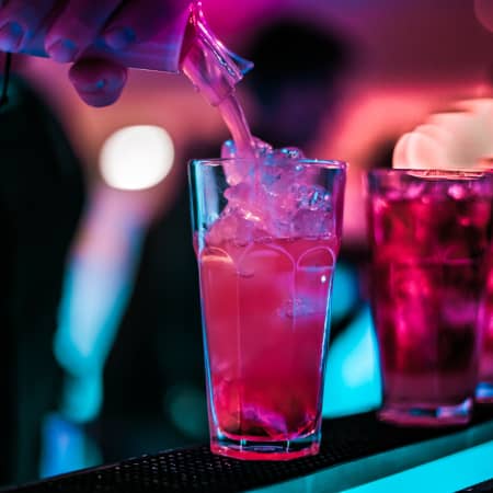 Drink being poured colored with neon lighting
