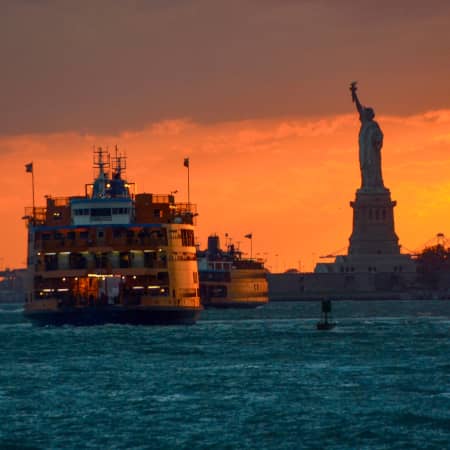 Staten Island Ferry near the Statue of Liberty at sunset